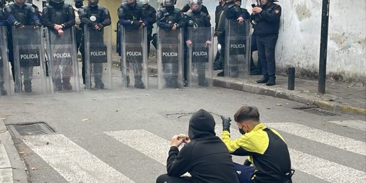 Dy fëmijë protestues ulen këmbëkryq para efektivëve
